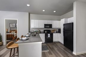 San Antonio apartment for rent - A modern kitchen with black appliances and white cabinets.