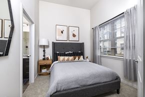 Mckinney apartment for rent - A bedroom with a large bed and a window with curtains.