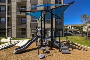 Austin apartment for rent - A playground with a blue umbrella and a slide.