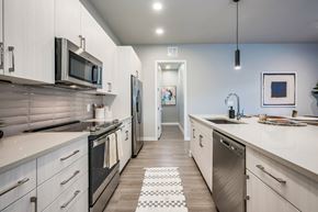 Houston apartment for rent - a kitchen with white cabinets and stainless steel appliances