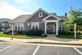 Raleigh apartment for rent - the front of a house with a driveway and a parking lot