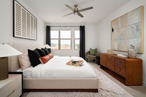 Austin apartment for rent - A bedroom with a large bed, a ceiling fan, and a painting on the wall.