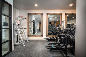 Austin apartment for rent - A gym with a mirror, treadmill, and exercise bikes.