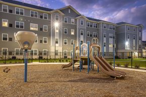 Columbus apartment for rent - Community playground with slides and climbing structures set within a landscaped outdoor area, with apartment buildings in the background.