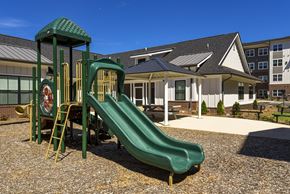 Charlotte apartment for rent - A green playground slide in front of a building.