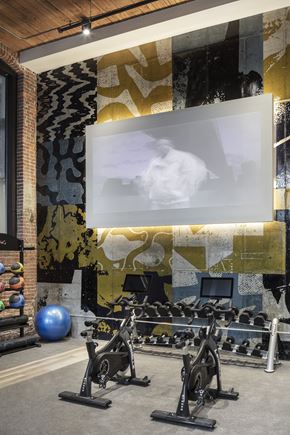 Wakefield apartment for rent - A gym with a brick wall and a screen displaying a man.