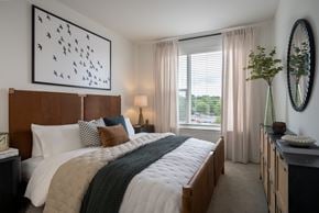 Silver Spring apartment for rent - A bedroom with a large bed and a painting on the wall.