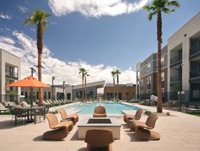 Las Vegas apartment for rent - A pool surrounded by chairs and palm trees.