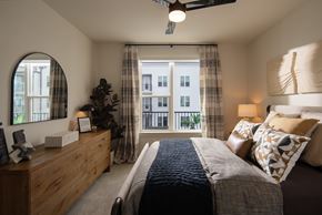 Charlotte apartment for rent - A bedroom with a large bed and a window with curtains.