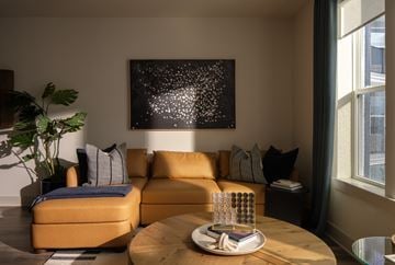 Charlotte apartment for rent - A living room with a yellow couch and a painting on the wall.