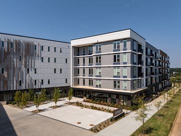 Charlotte apartment for rent - A modern building with a parking lot in front.