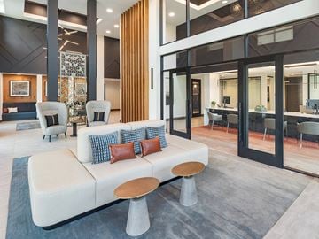 Houston apartment for rent - A modern living room with a white sofa and a grey rug.