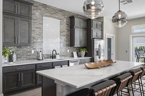 Perrysburg apartment for rent - Elegant community kitchen featuring a large island with bar seating, designer pendant lighting, and contemporary finishes throughout.