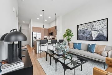 Charlotte apartment for rent - A modern living room with a grey couch, a black coffee table, and a large abstract painting on the wall.