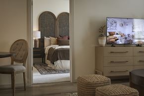 Sherman apartment for rent - A bedroom with a bed, a chair, and a dresser with a mirror.