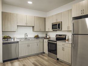 Sherman apartment for rent - A modern kitchen with wooden cabinets and stainless steel appliances.