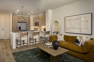 Del Valle apartment for rent - A living room with a brown couch, a coffee table, and a large painting on the wall.
