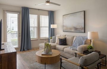 Kissimmee apartment for rent - A living room with a grey couch, a wooden coffee table, and a painting on the wall.