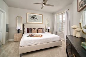 Houston apartment for rent - A bedroom with a large bed and a ceiling fan.