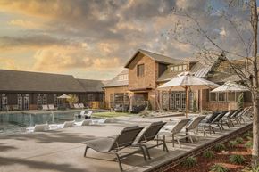 Princeton apartment for rent - A poolside area with lounge chairs and a building in the background.