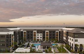 Fort Myers apartment for rent - A large apartment complex with a pool in the foreground.