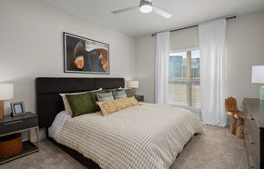 Killeen apartment for rent - a bedroom with a large bed and a ceiling fan