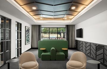 Austin apartment for rent - A modern living room with a green sofa and two beige armchairs.