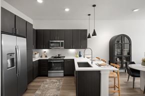 Austin apartment for rent - a kitchen with black cabinets and a white counter top and a stainless steel refrigerator