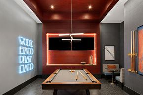Mclean apartment for rent - A pool table is in the middle of a room with a neon sign on the wall.