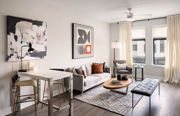Mclean apartment for rent - A modern living room with a white dining table and a grey sofa.