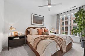 Charlotte apartment for rent - A bedroom with a large bed and a ceiling fan.