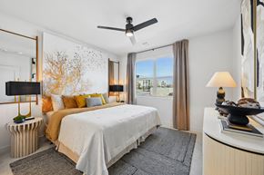 Las Vegas apartment for rent - A bedroom with a bed, a ceiling fan, and a window with a view of the city.