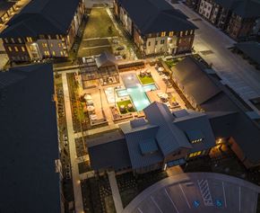 Princeton apartment for rent - A swimming pool is surrounded by a building and a parking lot.