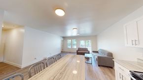 Ann Arbor apartment for rent - A spacious living room with a long wooden table and chairs.