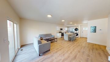 Ann Arbor apartment for rent - A living room with a grey couch and a wooden floor.