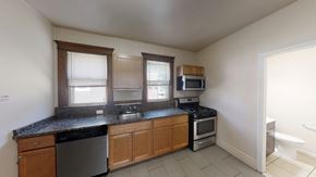Ann Arbor apartment for rent - A kitchen with a black granite countertop and wooden cabinets.