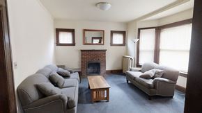 Ann Arbor apartment for rent - A living room with a grey couch, a fireplace, and a wooden coffee table.