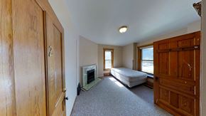 Ann Arbor house for rent - A room with a fireplace and a bed.