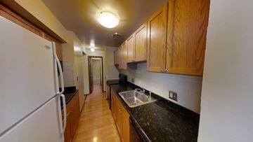 Ann Arbor apartment for rent - A kitchen with wooden cabinets and a white refrigerator.