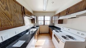Ann Arbor apartment for rent - A kitchen with a stove, sink, and cabinets.