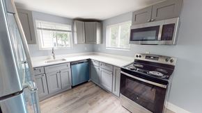 Ann Arbor apartment for rent - A kitchen with a stove, refrigerator, and cabinets.