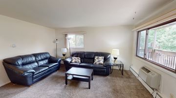 Ann Arbor apartment for rent - A living room with two black leather couches and a coffee table.