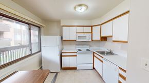 Ann Arbor apartment for rent - A kitchen with white appliances and wooden cabinets.