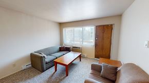 Ann Arbor apartment for rent - A living room with a brown couch, a grey couch, and a wooden coffee table.