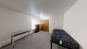 Ann Arbor apartment for rent - A room with a bed, a bench, and a wardrobe.