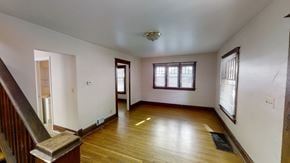 Ann Arbor apartment for rent - A room with wooden floors and a staircase leading to another room.
