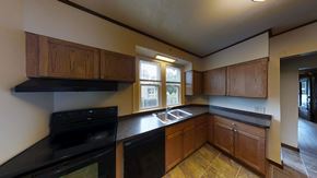 Ann Arbor apartment for rent - A kitchen with black appliances and wooden cabinets.