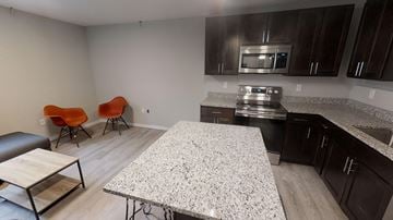 Ann Arbor apartment for rent - A kitchen with a granite countertop and a dining table with chairs.