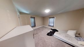 Ann Arbor apartment for rent - A bedroom with a bed, pillow, and a window with curtains.
