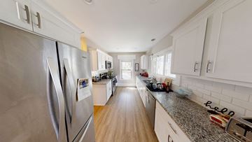 Ann Arbor apartment for rent - A kitchen with a stainless steel refrigerator and wooden floors.